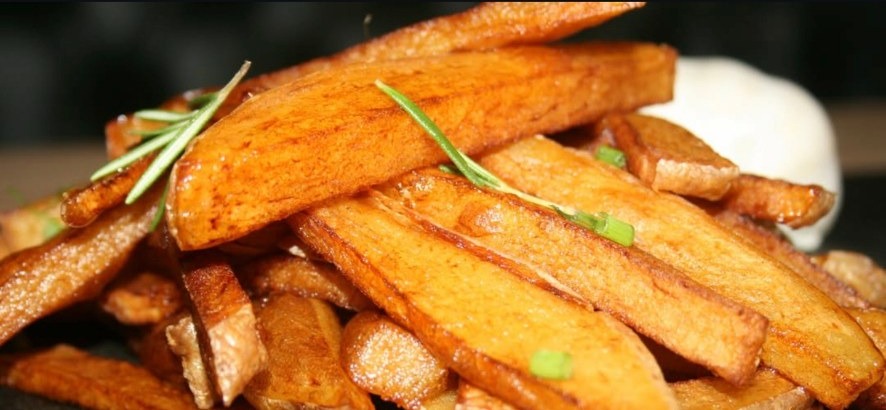 Golden hand-cut chips stacked high with rosemary